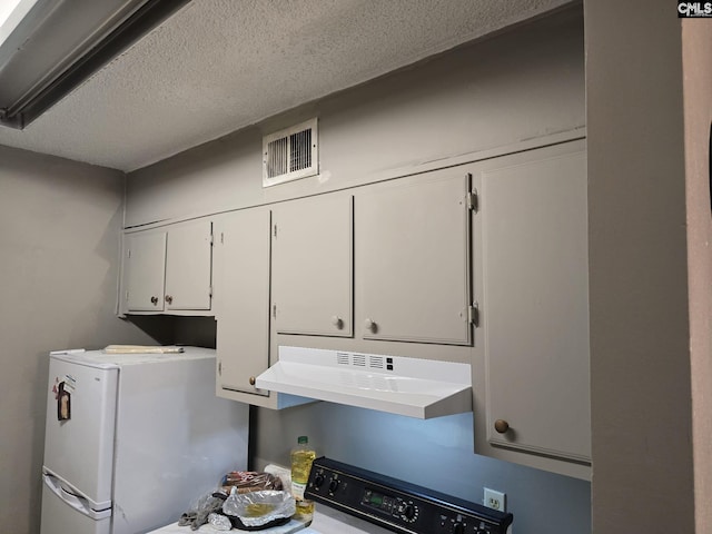 interior space with white cabinetry, stove, white refrigerator, and a textured ceiling