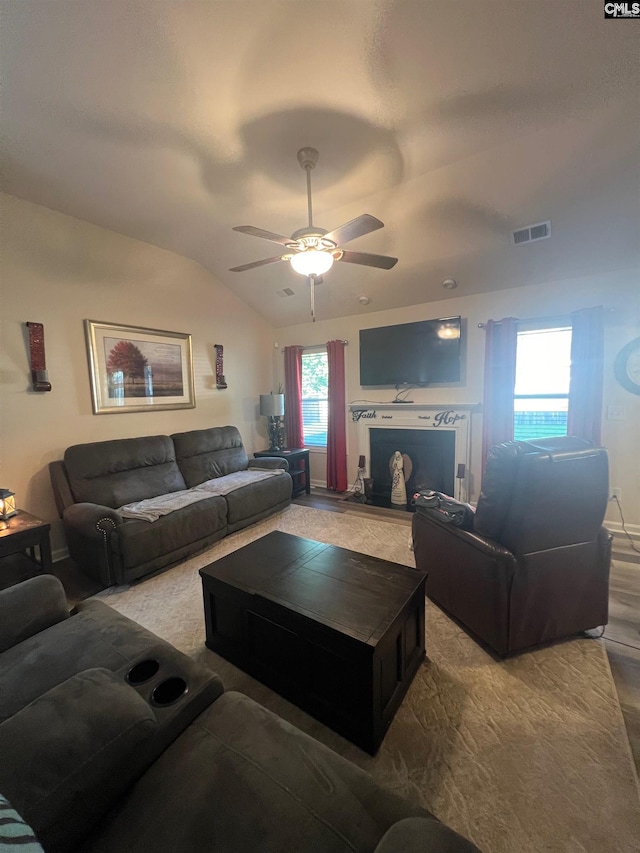 living room featuring a ceiling fan, visible vents, and vaulted ceiling