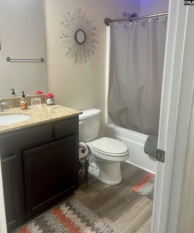 bathroom with shower / bath combo with shower curtain, vanity, toilet, and wood finished floors