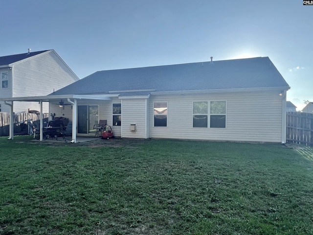 rear view of property with a yard, fence, and a patio