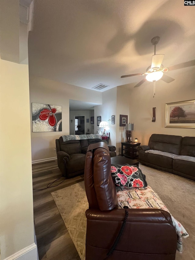 living area with baseboards, wood finished floors, visible vents, and a ceiling fan