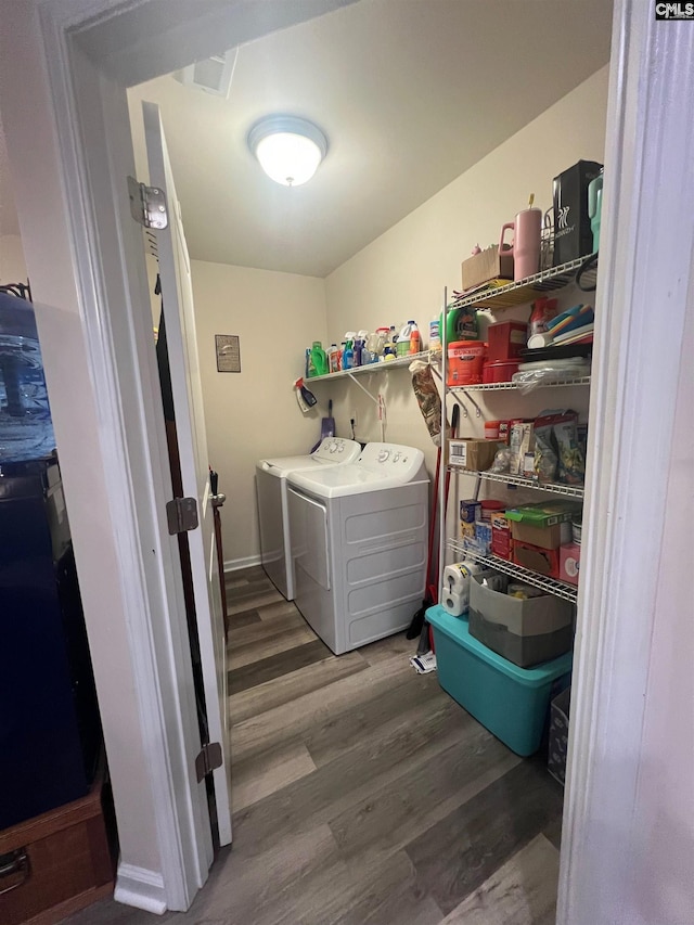 laundry area featuring laundry area, wood finished floors, and washer and dryer