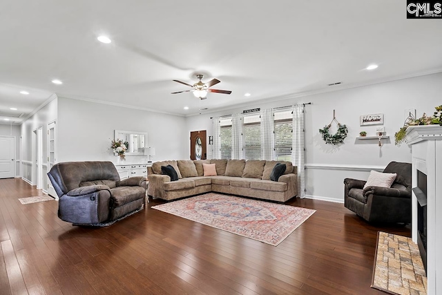 living room featuring dark hardwood / wood-style flooring, ceiling fan, and ornamental molding