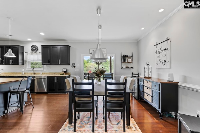 dining space featuring sink, ornamental molding, and dark hardwood / wood-style flooring