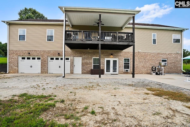 back of house featuring a garage and ceiling fan