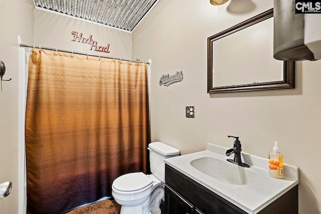 bathroom featuring toilet, vanity, and curtained shower