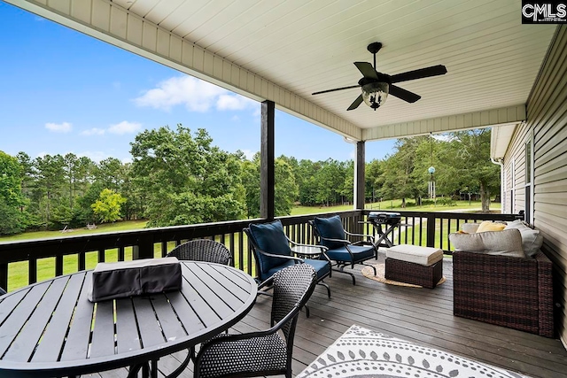 wooden terrace with ceiling fan and an outdoor hangout area