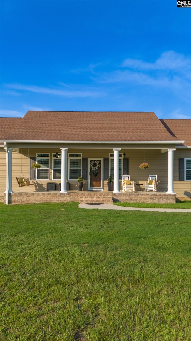 back of house featuring a porch and a lawn