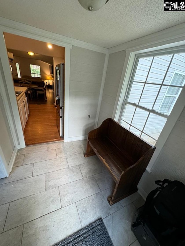 interior space featuring light tile patterned floors and a textured ceiling