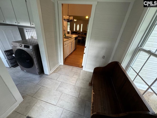 corridor featuring sink, a chandelier, washer / dryer, and light wood-type flooring