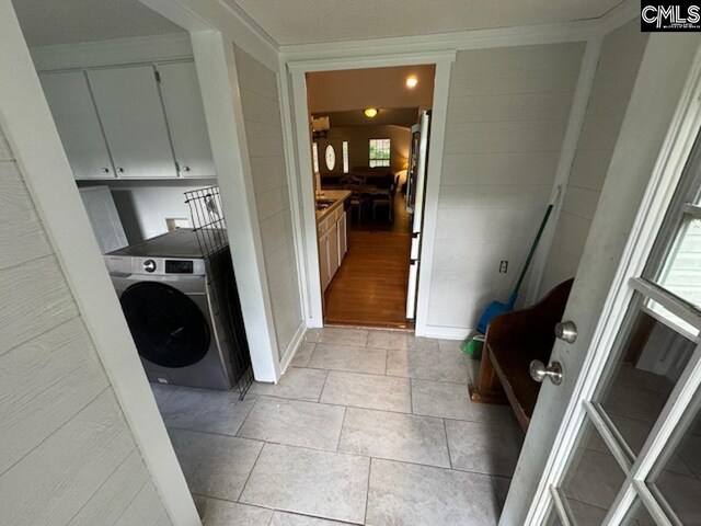 laundry room with washer / clothes dryer, light hardwood / wood-style flooring, and cabinets