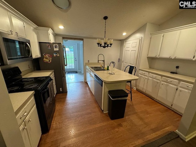 kitchen with appliances with stainless steel finishes, a kitchen island with sink, a breakfast bar area, and wood-type flooring