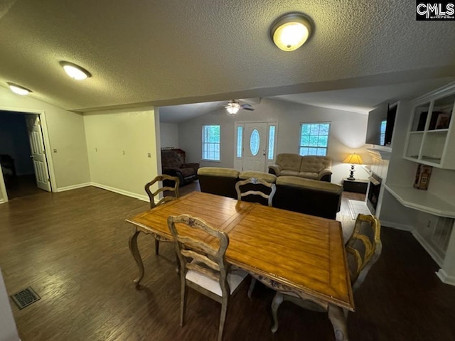 dining space with ceiling fan, vaulted ceiling, a textured ceiling, and wood-type flooring