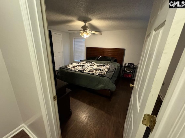 bedroom featuring a textured ceiling, ceiling fan, and dark hardwood / wood-style flooring