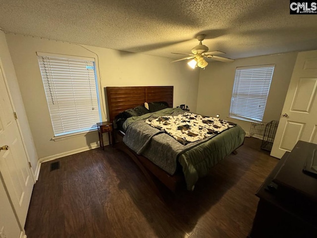 bedroom with dark hardwood / wood-style flooring, a textured ceiling, and ceiling fan