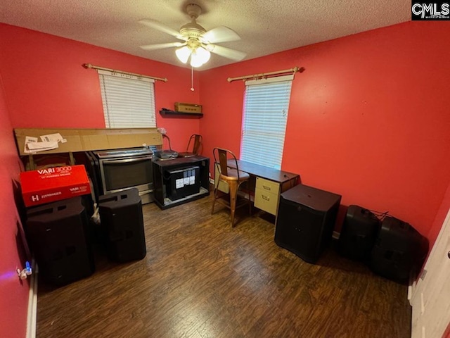 office space with ceiling fan, dark wood-type flooring, and a textured ceiling