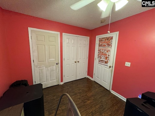 entrance foyer with ceiling fan, a textured ceiling, and dark hardwood / wood-style flooring