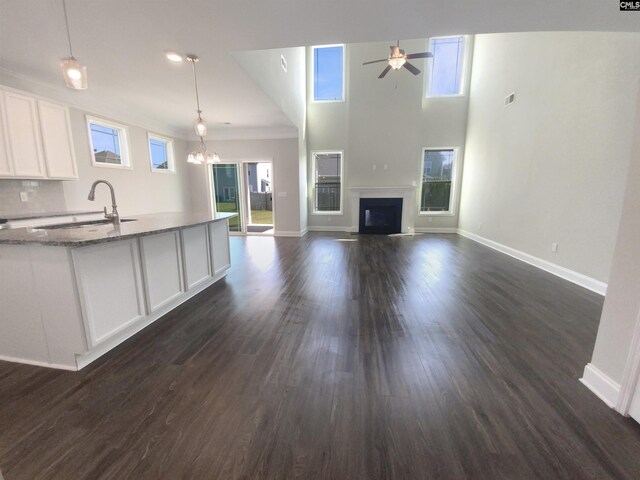 kitchen with a healthy amount of sunlight, light stone counters, and dark hardwood / wood-style floors