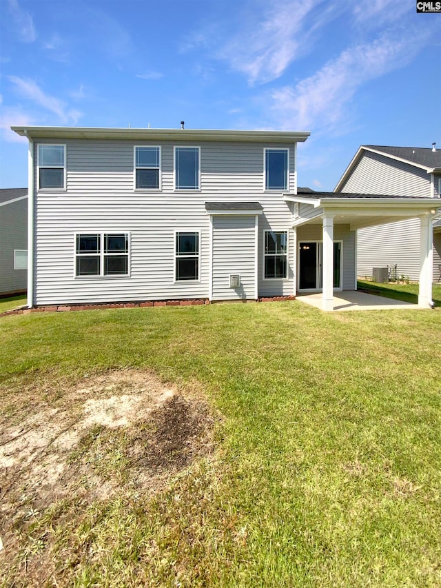 back of property with a lawn and a patio area