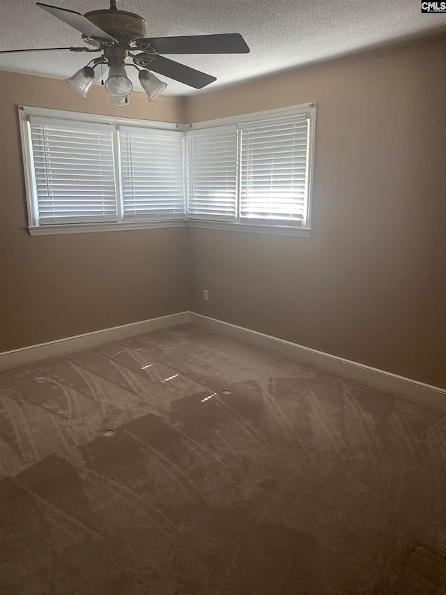 carpeted spare room with ceiling fan and a textured ceiling