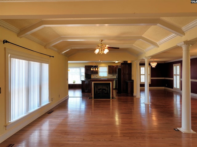 unfurnished living room featuring ceiling fan with notable chandelier, hardwood / wood-style floors, decorative columns, ornamental molding, and lofted ceiling