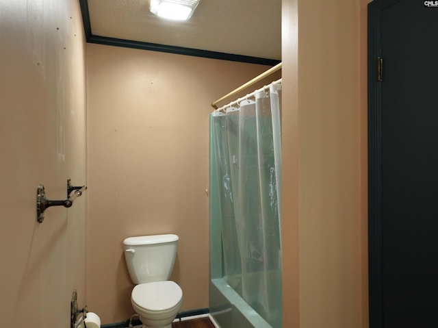 bathroom featuring toilet, shower / bath combo with shower curtain, and a textured ceiling