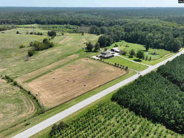 drone / aerial view featuring a rural view and a view of trees
