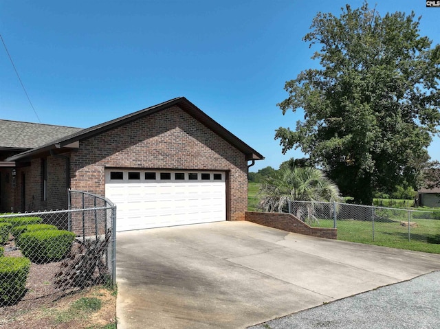 view of side of home featuring concrete driveway, fence, a garage, and brick siding