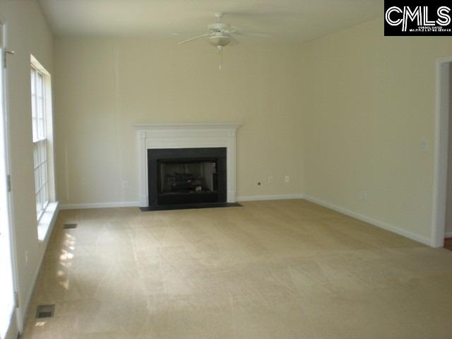 unfurnished living room with light carpet and ceiling fan