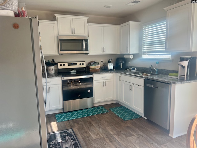 kitchen with white cabinetry, stainless steel appliances, and dark hardwood / wood-style flooring