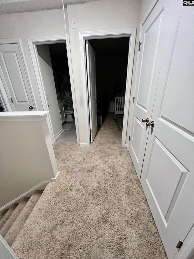 hallway featuring light colored carpet