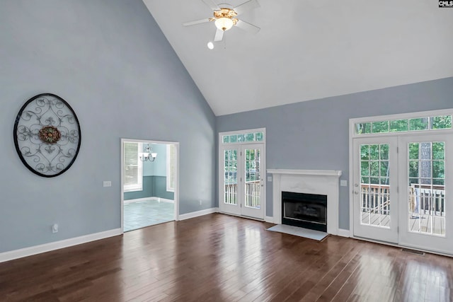 unfurnished living room with plenty of natural light, a high end fireplace, high vaulted ceiling, and dark hardwood / wood-style flooring