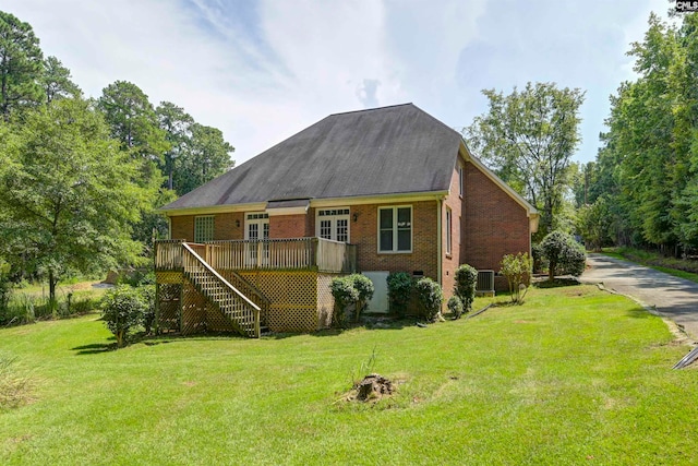 view of front of property with a wooden deck, central AC unit, and a front lawn