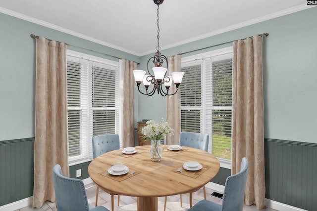 tiled dining space featuring ornamental molding and an inviting chandelier