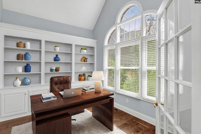 home office with a healthy amount of sunlight, vaulted ceiling, and wood-type flooring