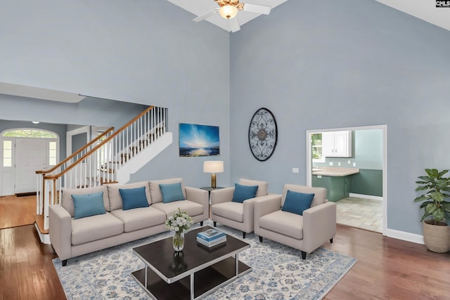 living room with high vaulted ceiling, wood-type flooring, ceiling fan, and a healthy amount of sunlight