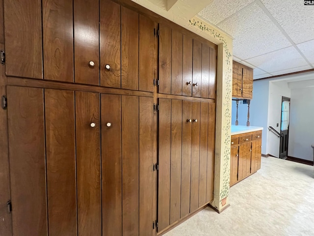 room details with a paneled ceiling, baseboards, and carpet