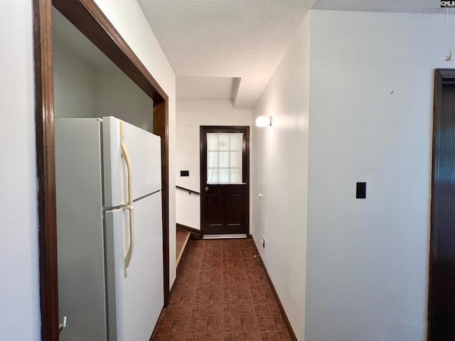 interior space with a textured ceiling and baseboards