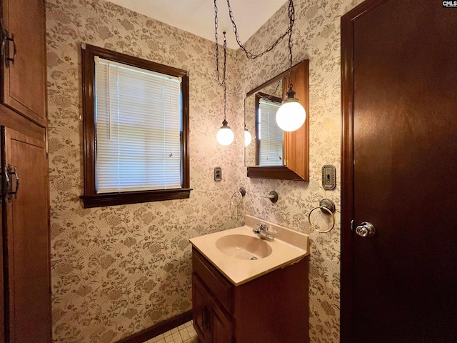 bathroom with wallpapered walls and vanity