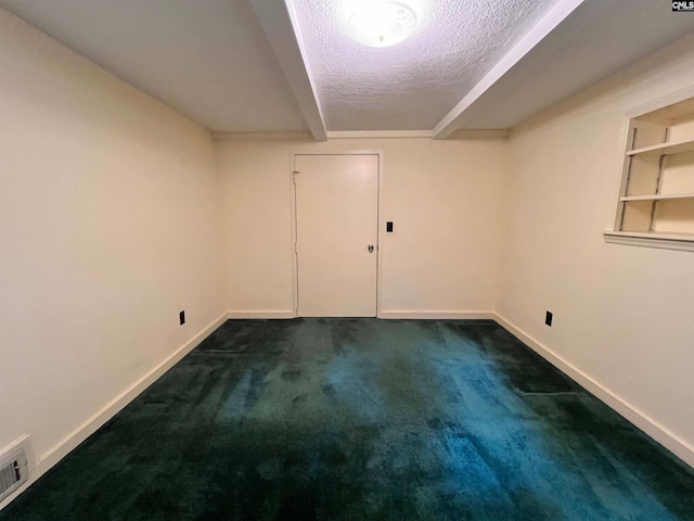 finished basement with visible vents, dark carpet, a textured ceiling, and baseboards