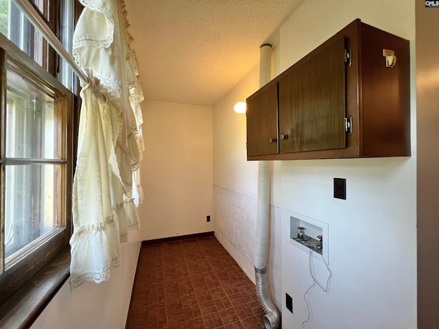 washroom with washer hookup, cabinet space, brick patterned floor, hookup for an electric dryer, and a textured ceiling