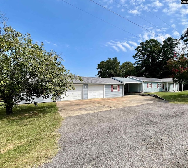 ranch-style home with aphalt driveway, a front yard, metal roof, and a garage