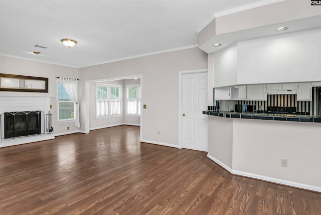 kitchen with black range oven, crown molding, tasteful backsplash, tile counters, and dark hardwood / wood-style flooring