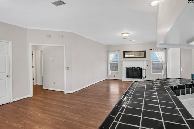 unfurnished living room featuring lofted ceiling and hardwood / wood-style floors