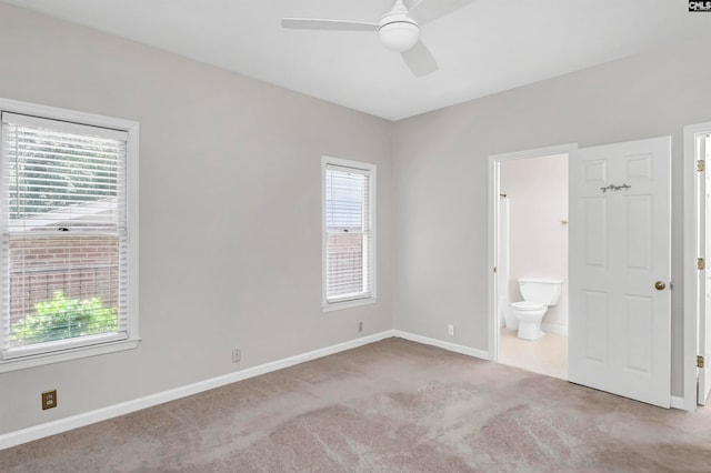 empty room with ceiling fan, light colored carpet, and a healthy amount of sunlight