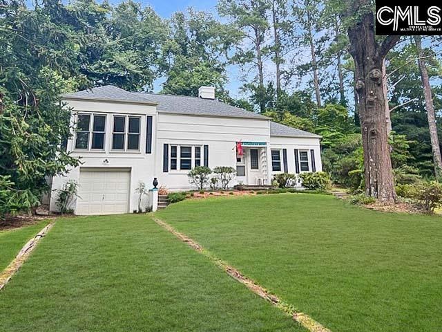 view of front of house with a garage and a front lawn