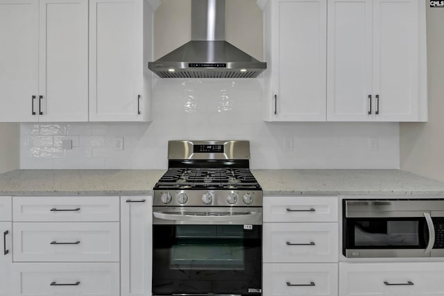 kitchen featuring white cabinetry, appliances with stainless steel finishes, and wall chimney range hood