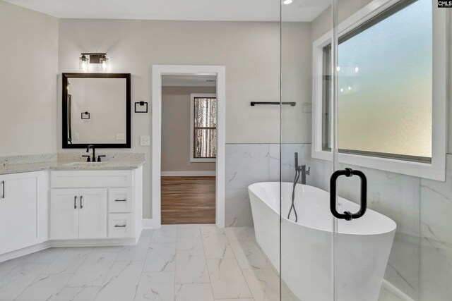 bathroom featuring a bathtub, tile walls, and vanity