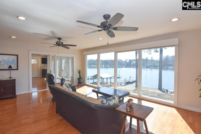 living room featuring hardwood / wood-style flooring, a wealth of natural light, and ceiling fan