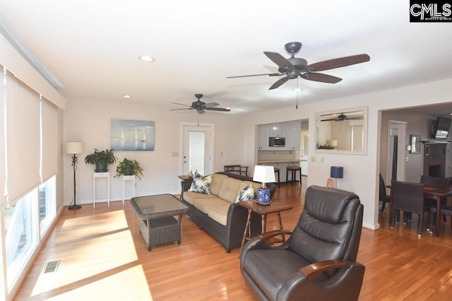 living room featuring ceiling fan and light wood-type flooring